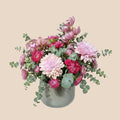 AMABILE FLOWER SHOP mixed floral arrangement with pink and purple orchids, chrysanthemums, and eucalyptus in a grey vase.