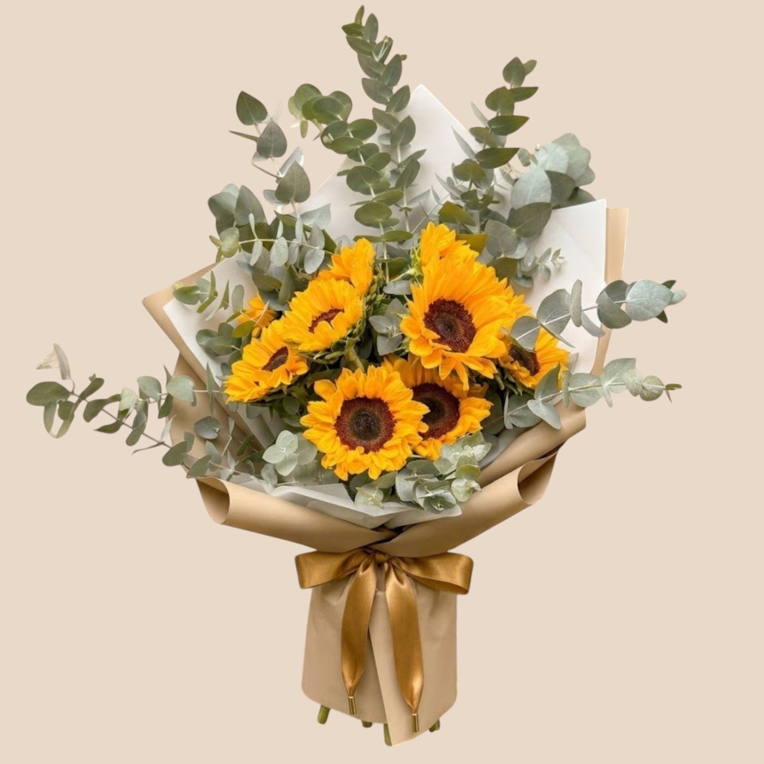 AMABILE FLOWER SHOP The Golden Hour bouquet features six bright yellow sunflowers with dark centers, accented by fresh green eucalyptus leaves, wrapped in brown paper and tied with a beautiful ribbon.